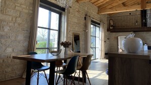 Un comedor rústico con una mesa de madera, sillas y una araña.