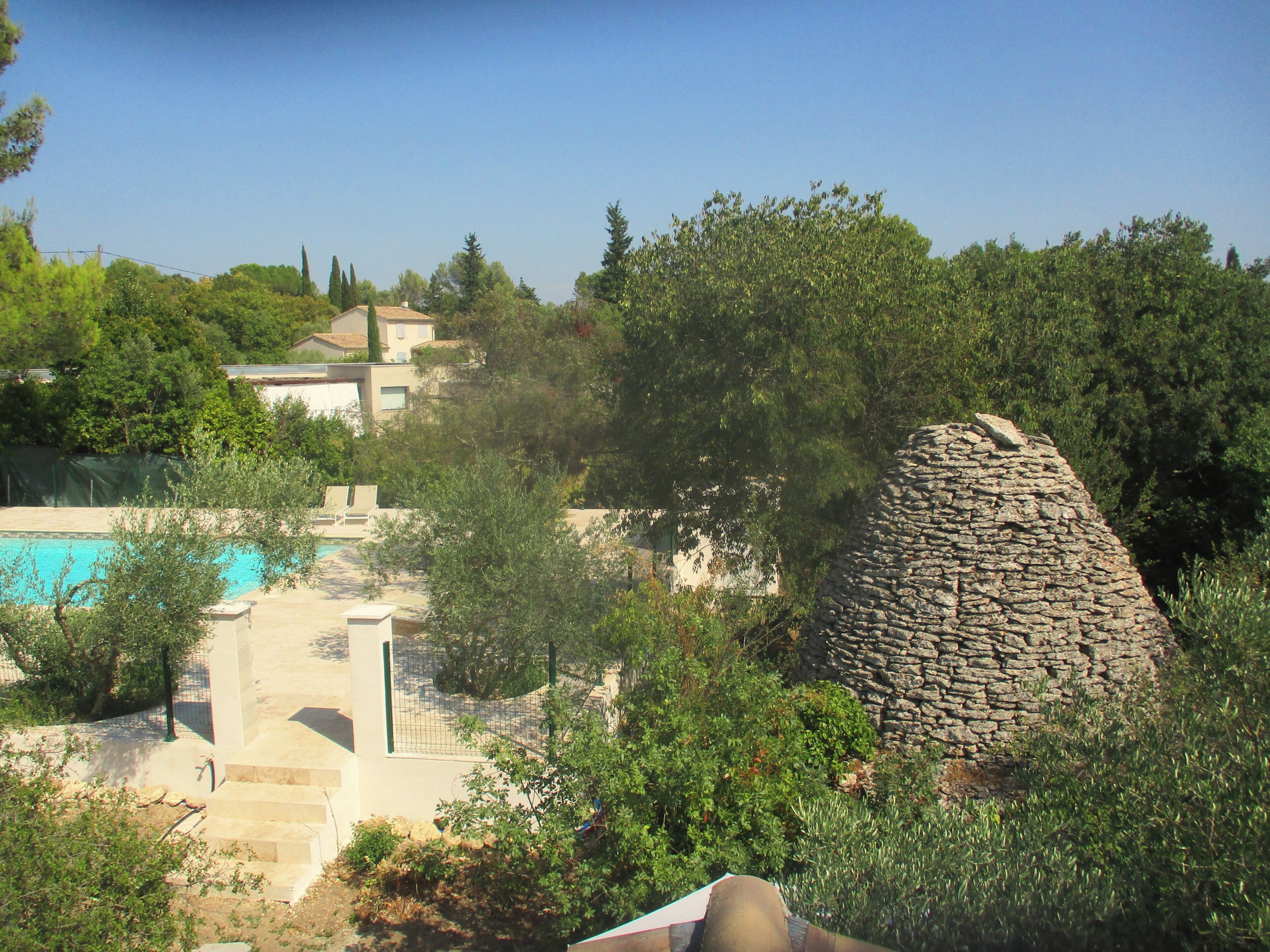 A stone structure, a swimming pool, and surrounding greenery.