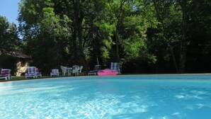 Une piscine aux eaux cristallines, bordée de chaises longues et de tables.