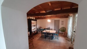 A dining area with a wooden table and chairs, a bookshelf, and a fan. - Children's paradise calm nights, guest animals, plenty of Playmobilss (Troncens)