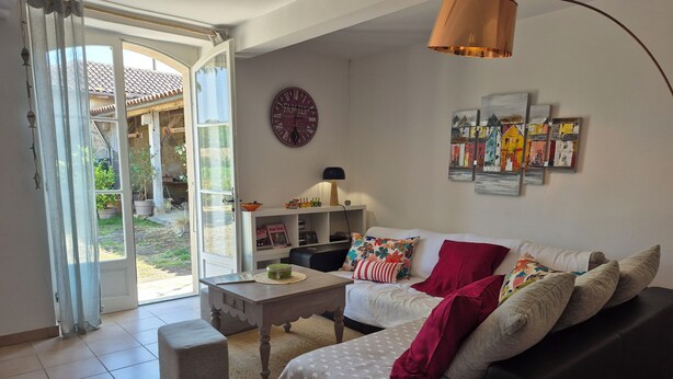 A living room with a sofa, a coffee table, and a bookshelf. There is a door leading to a balcony. - Children's paradise calm nights, guest animals, plenty of Playmobilss (Troncens)