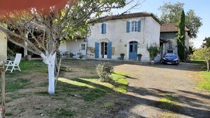 A two-story house with a gravel driveway, a parked car, and a white chair outside. - Children's paradise calm nights, guest animals, plenty of Playmobilss (Troncens)