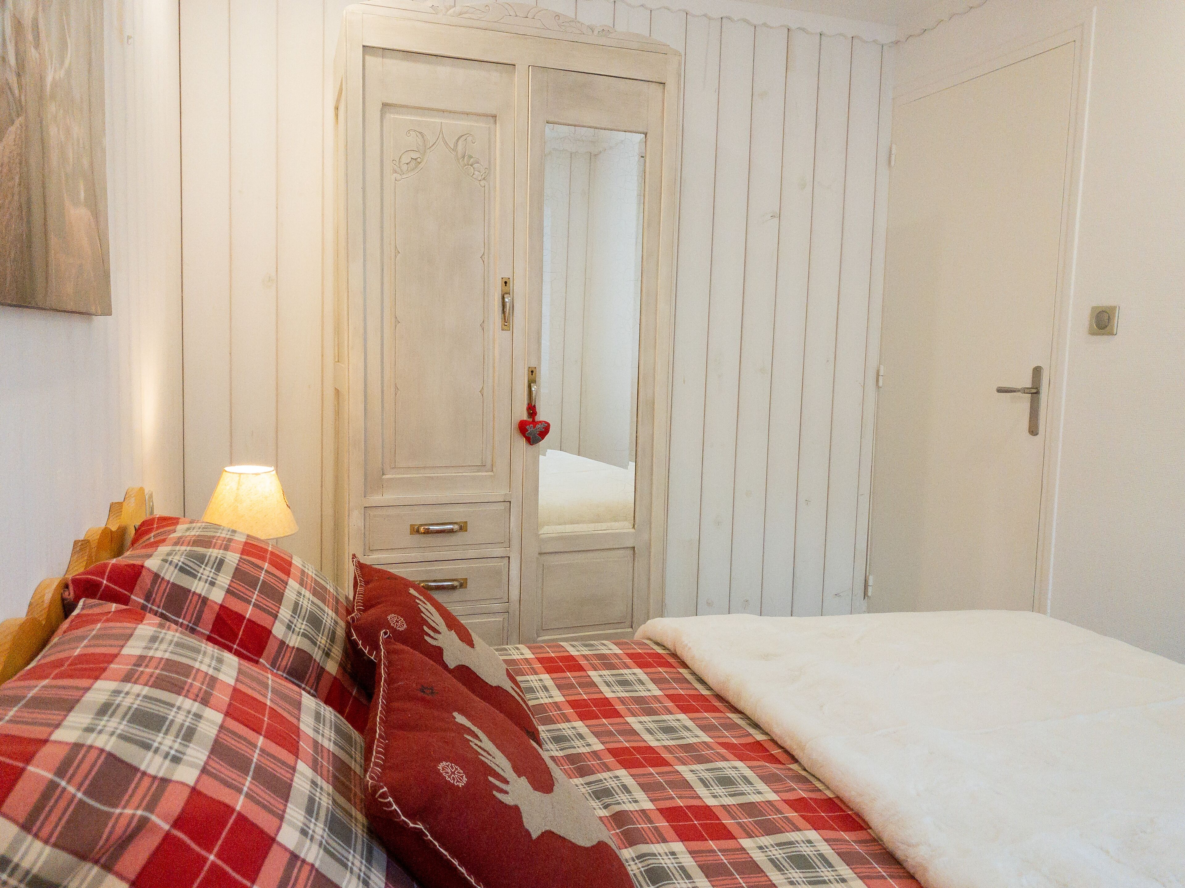 Ein Schlafzimmer mit Bett, Nachttisch, Kommode und Tür.