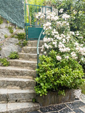 A stone staircase with a metal handrail, surrounded by lush greenery and white flowers. - Cauterets rare chalet heated pool summer WIFI, electric charging point 11kwh (Cauterets)