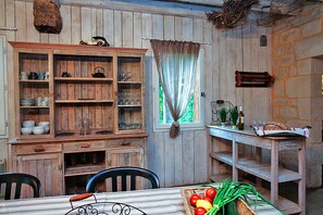 Una cucina rustica con mobili in legno, un tavolo da pranzo e un muro in pietra.