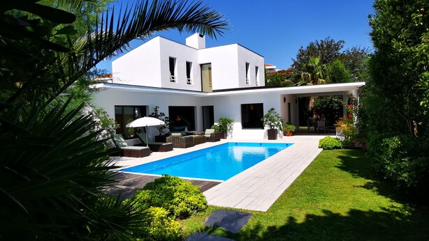 A modern house with a swimming pool, surrounded by lush greenery and a clear blue sky. - beautiful modern villa with heated pool near: sea, golf, tennis and shops (Anglet)