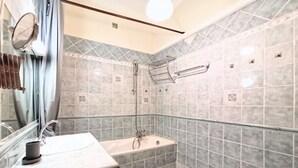A bathroom with a sink, mirror, and shower area. - Provencal Style and Large 1 Bedroom Rue Florian (Cannes)
