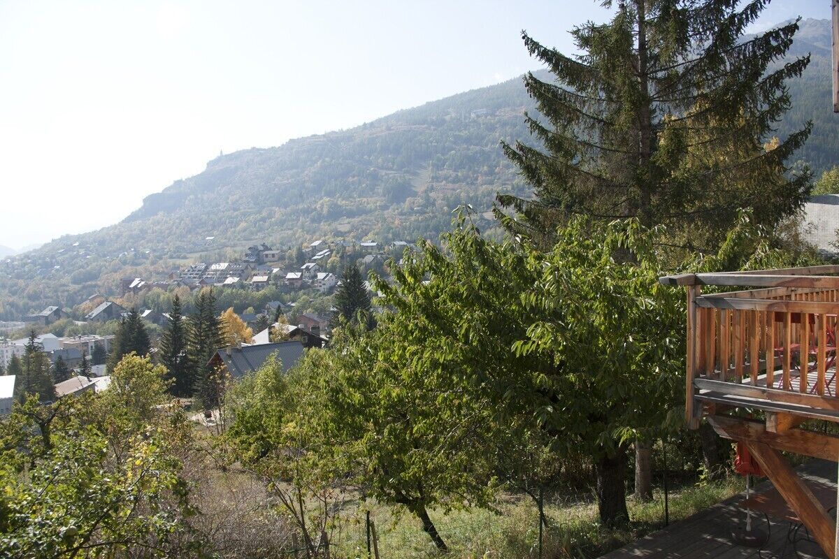 A view of a mountainous area with houses and a wooden deck.