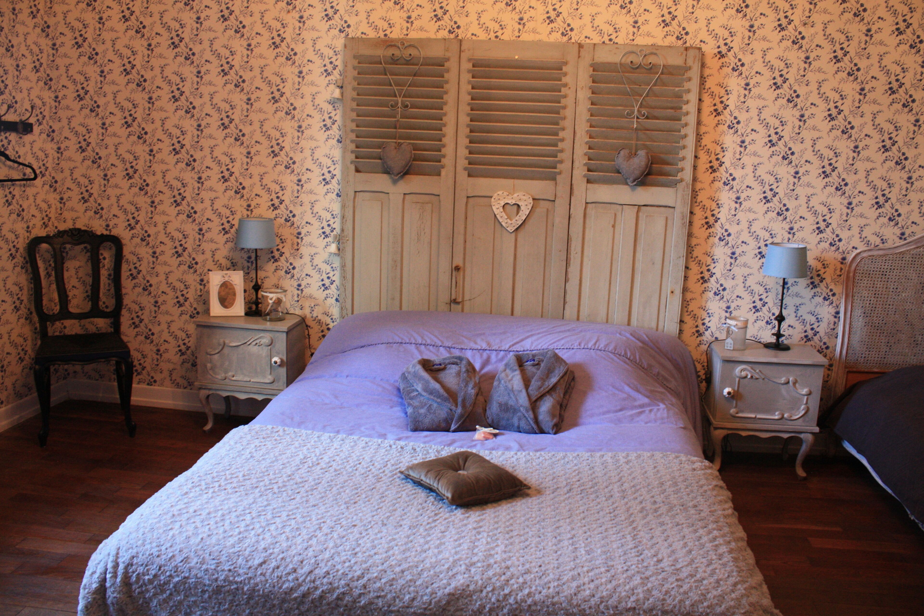 A bedroom with a bed, two nightstands, a chair, and a dresser.