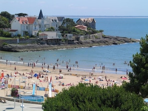 A beach with people, a pool, and buildings in the background. - Comfortable, quiet "CôtéPlage" gîte-Covered terrace-Garden (Vaux-Sur-Mer)