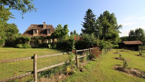 A rustic house with a sloped roof, surrounded by a fenced yard with a wooden fence and a small shed. - Dordogne Valley, 4 * holiday house, exclusive pool, 12kms from Bergerac (Bergerac)