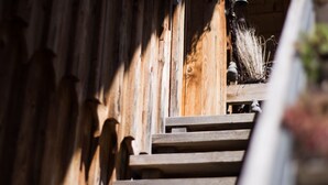 A wooden staircase leading up to a building with a sloped roof.