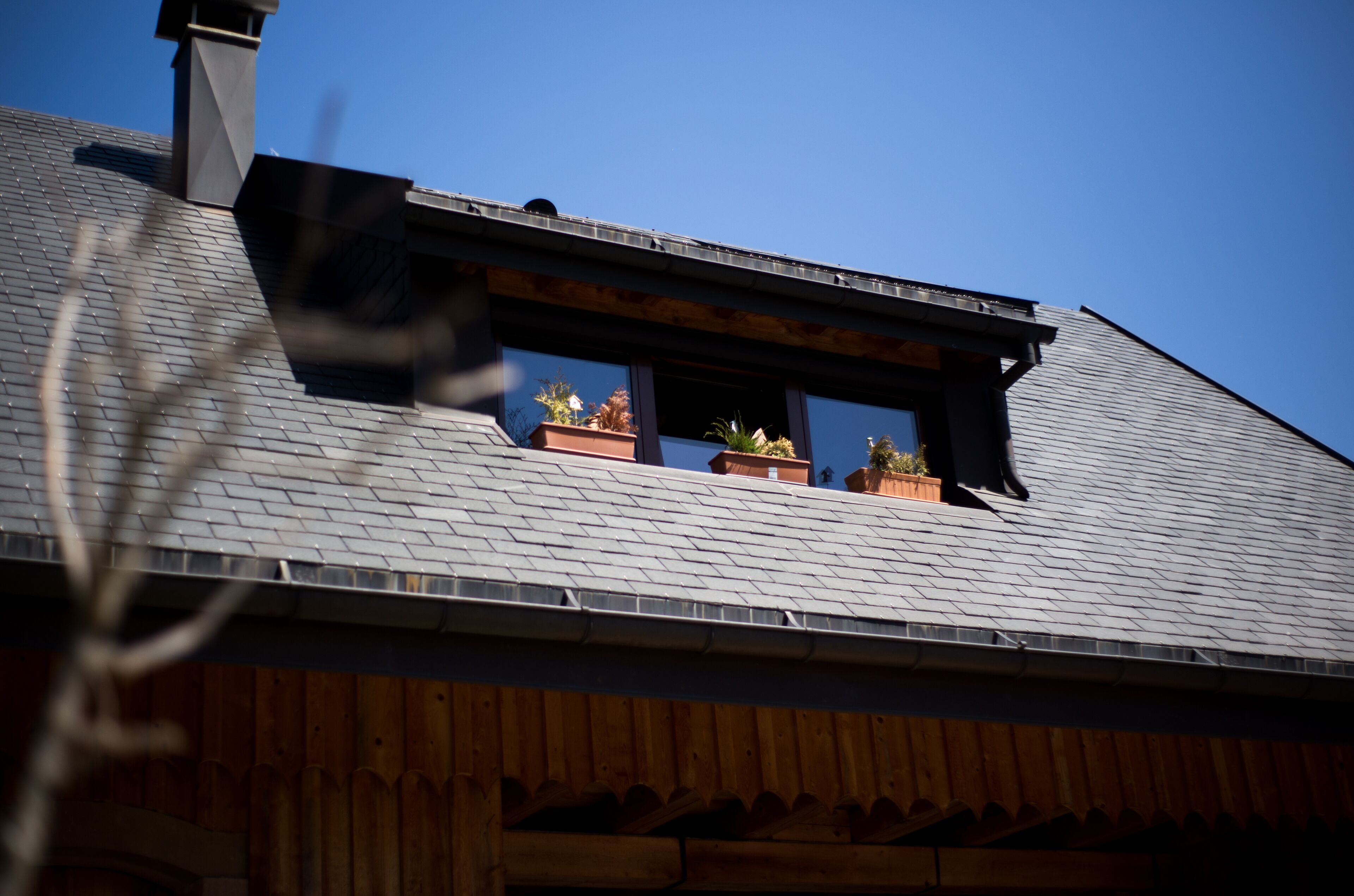 Ein Gebäude mit einem geneigten Dach, Holzwandverkleidung und einem Fenster mit Blick zum Himmel.