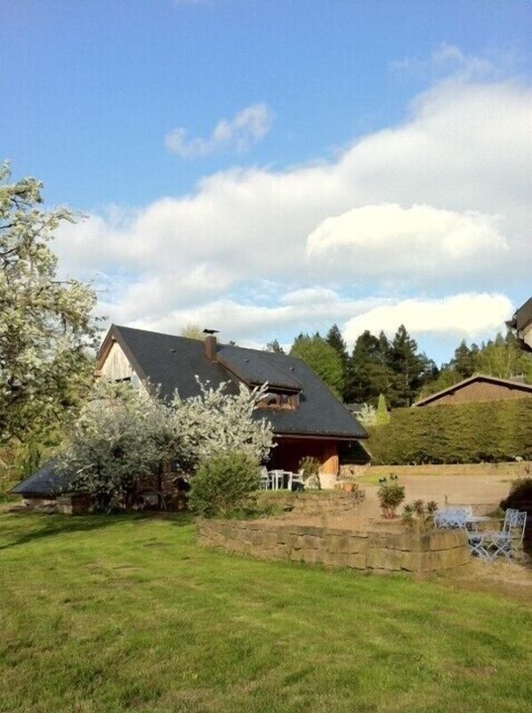 Set amidst a serene landscape, this two-story house offers a peaceful retreat with a garden and a lawn.