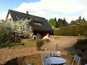 Guests can dine or relax on the spacious porch with outdoor seating and enjoy the peaceful garden surroundings.