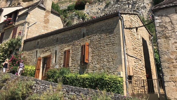 A historic stone building with a steep, rocky hill behind it. - Charming cottage and nature, 18 ha, Périgord Noir-Dordogne -Lot -PISCINE and private SPA (Orliaguet)