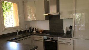 Eine moderne Küche mit einem Backofen von Bosch, einer Kaffeemaschine und einem Spülbecken.