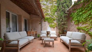 Ein Patio mit einer Sofagruppe, zwei Sesseln und einem Couchtisch.