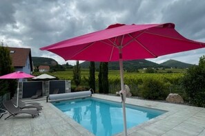 A swimming pool with lounge chairs and a pink umbrella. - Cottage with heated pool, near Eguisheim (Vœgtlinshoffen)