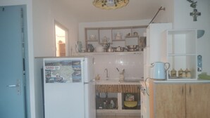 A kitchen with a refrigerator, cabinets, and a sink.