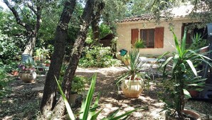 A rustic house with a garden, surrounded by trees and potted plants. - STUDIO 15 min from Pont du Gard and Avignon—swimming and canoeing—1 hour from the sea and mountains (Rochefort-Du-Gard)