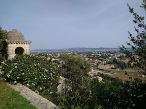 A stone structure with a dome and archway, surrounded by greenery.