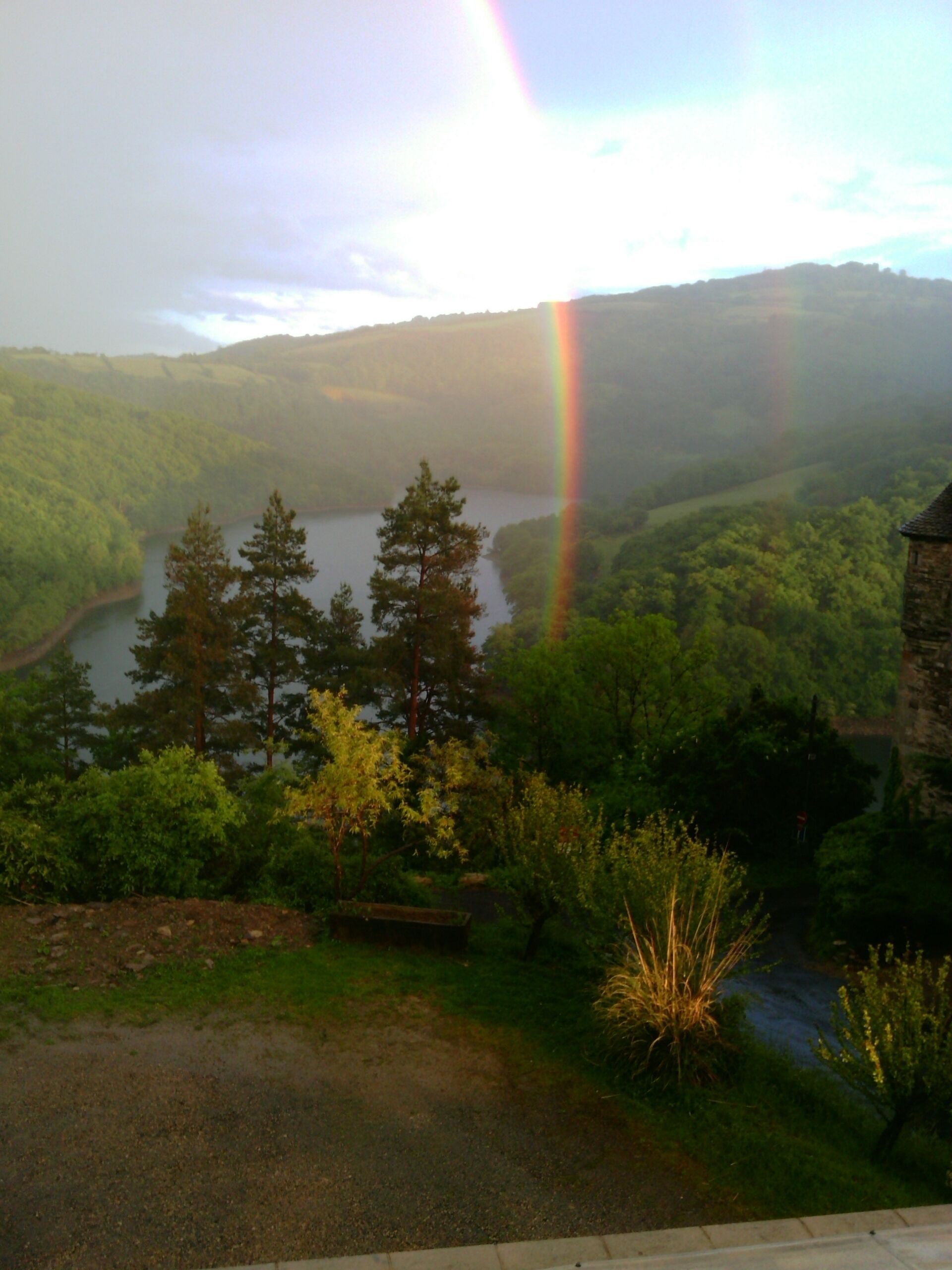 A view of a lake surrounded by trees and hills.
