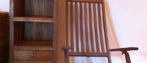Een houten stoel en een houten kast met planken.
