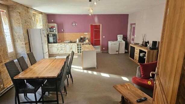 A compact living space with a dining area, kitchenette, and a red door. - APARTMENT / VACATION RENTAL: 3 BEDROOMS, FOR 1 TO 6 PEOPLE (Vayrac)