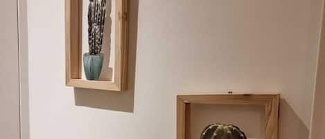 Two framed cactus plants on a wall.