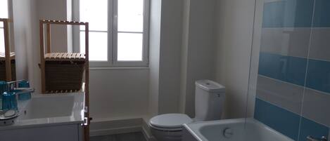 A bathroom with a bathtub, toilet, and sink.