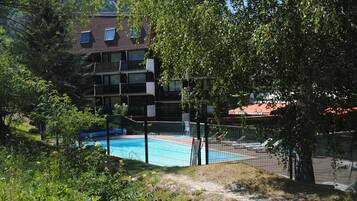 Una piscina al aire libre, una piscina climatizada