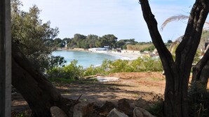 A coastal view with a sandy beach, a clear blue sea, and a few buildings in the background. - Studio 2 persons propriano (Propriano)