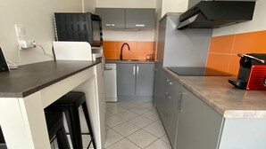 A compact kitchen with grey cabinets, a black countertop, and a tiled floor. - Appt 55m², 4-5 pers, 100m beach, parking, adult bike hire, WIFI (Quiberon)