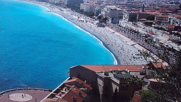 A coastal cityscape with a long beach, buildings, and a clear blue sea.