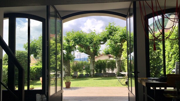 Un intérieur moderne avec de grandes portes vitrées donnant sur un jardin.