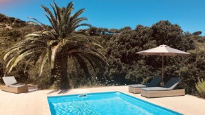 A swimming pool with lounge chairs and an umbrella, surrounded by greenery and hills. - Beautiful villa with pool, sea view, large garden and beach 7mn walk to Campomoro (Belvédère-Campomoro)