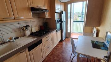 Une cuisine dotée de meubles en bois, d’un évier, d’une cuisinière et d’un coin repas avec une table et des chaises.