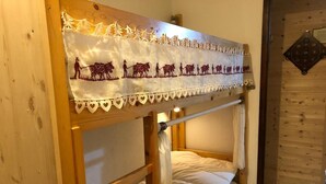 Una cama litera con cabecera decorativa que muestra una escena campestre.