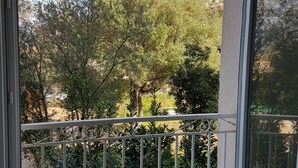 A balcony with a white railing, overlooking a garden with various trees and shrubs. - 50 m2 apartment with terrace on the ground floor of a villa (Calvi)