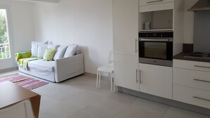 A modern kitchen with white cabinets and a built-in oven. - 50 m2 apartment with terrace on the ground floor of a villa (Calvi)