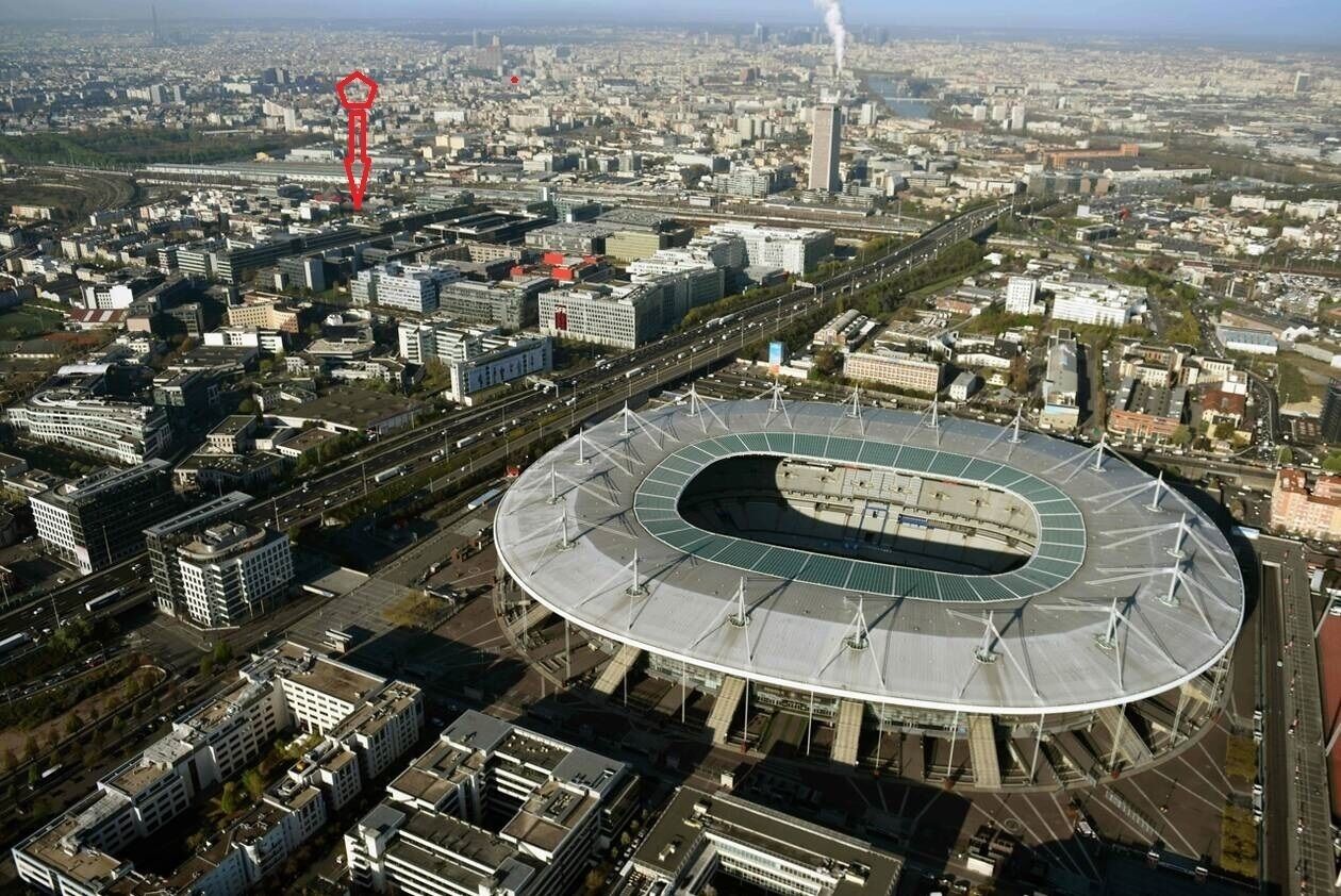 Vista aérea de un estadio con diseño circular, rodeado de edificios e infraestructura urbana.