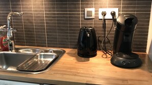 Une cuisine équipée d’un évier en acier inoxydable, d’une machine à café et d’un lave-vaisselle Siemens.