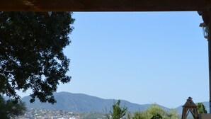 A table with breakfast items and a view of a coastal town and mountains. - Villa A LISCIA Marinca (Olmeto)