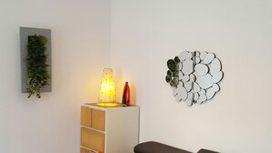 A modern living room with a grey sofa, red cushions, a small table, and a red rug. - Toulouse Canal du Midi (Toulouse)