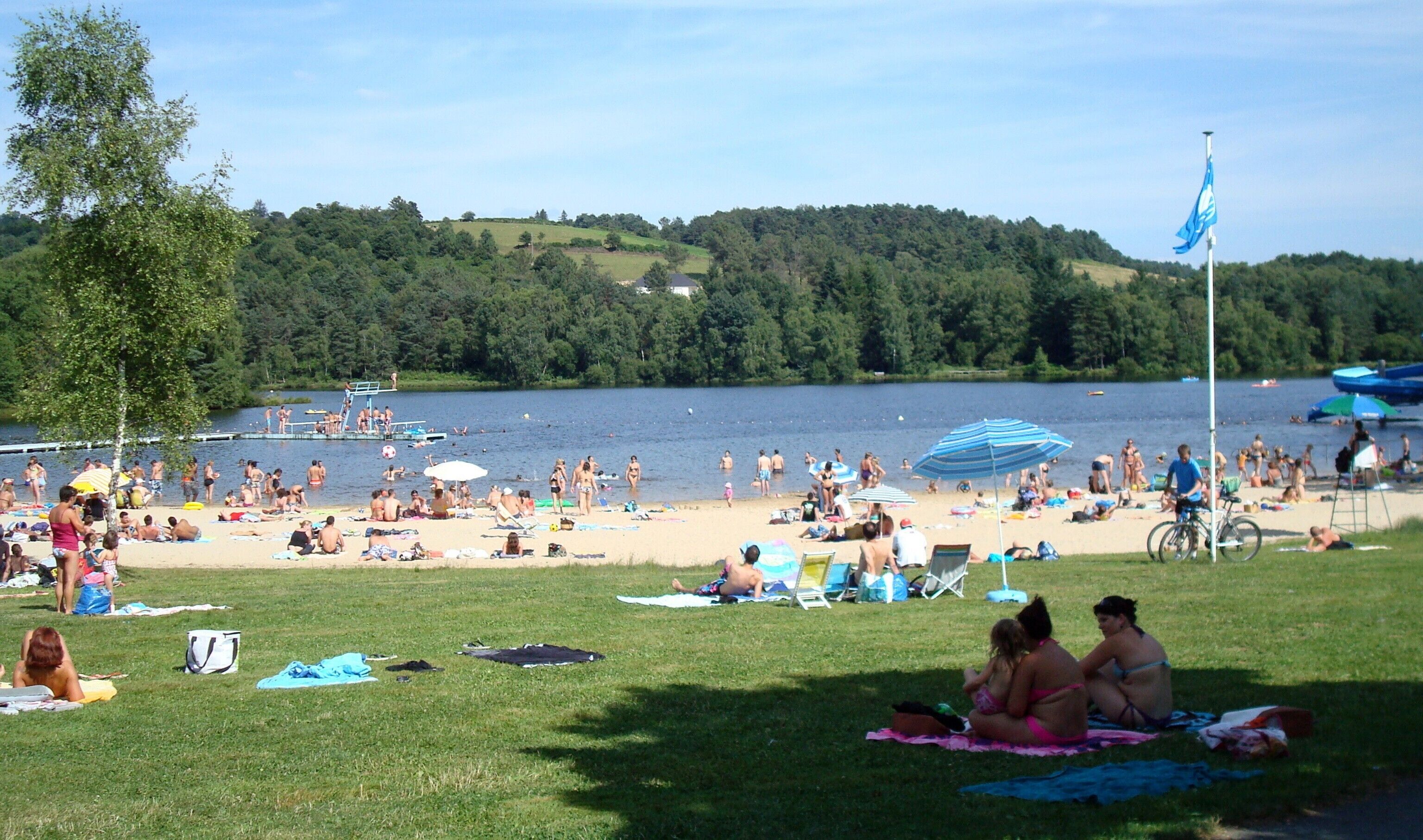 A beach with people sunbathing, swimming, and playing.