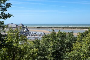 A coastal town with buildings, a beach, and a view of the sea.