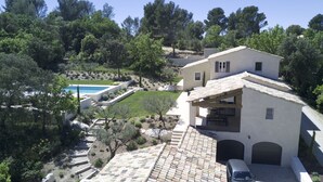 A Mediterranean-style villa with a swimming pool, terraced stone roof, and a garden with mature trees. - Bastide provençale 12 pers with swimming pool, 2 steps from Saint-Rémy-de-Pce (Eyragues)