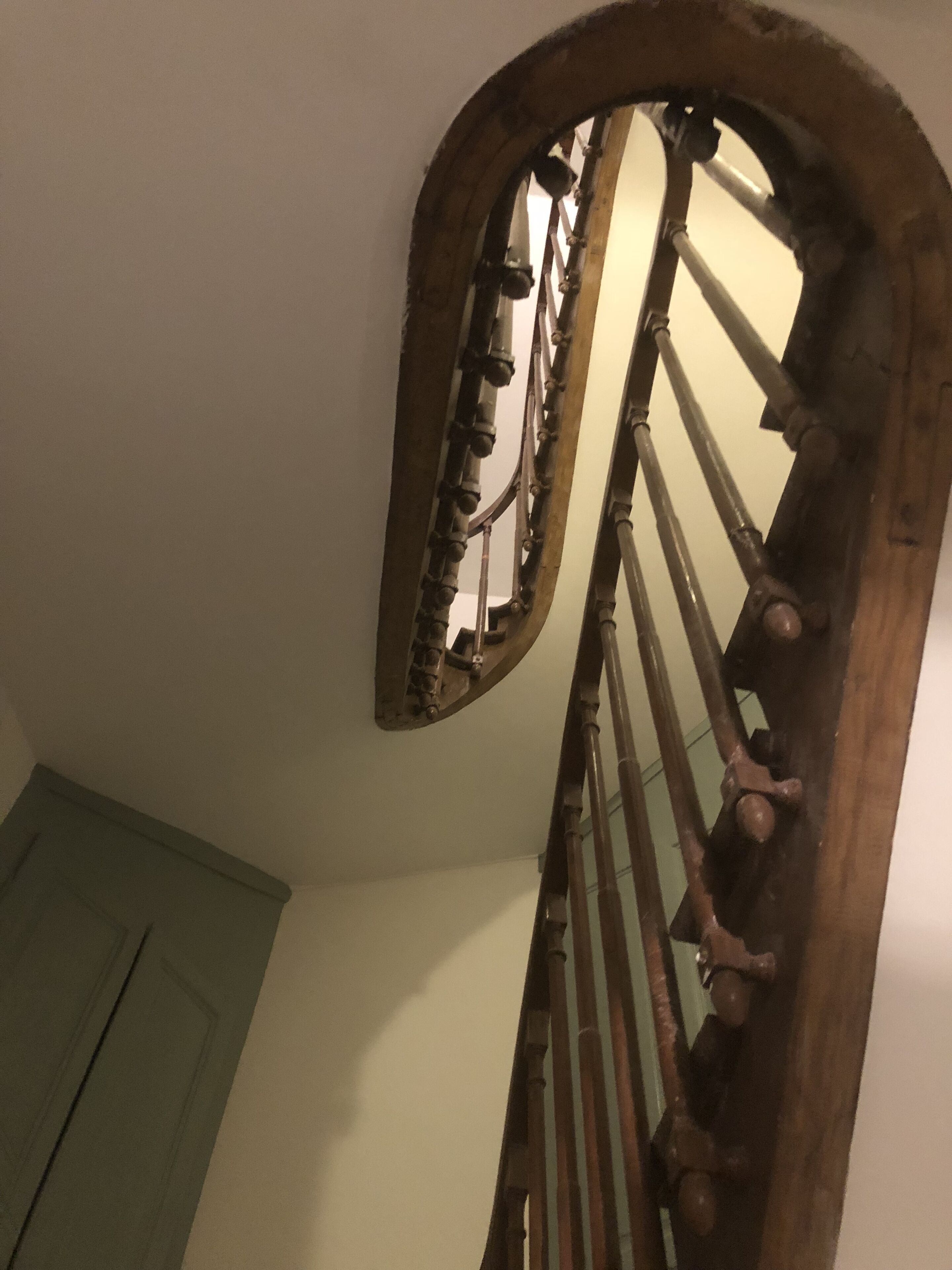 Una escalera de madera con un diseño curvo e barandillas metálicas.
