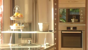 A modern kitchen with a stainless steel range hood, a Bosch oven, and a double sink.